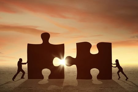 2 puzzle pieces merging together
